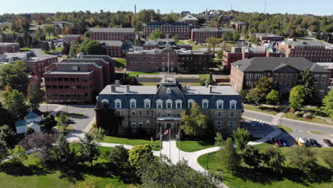 aerial: moving forward while tilting up to show sir howard douglas hall on the unb fredericton campus in center frame