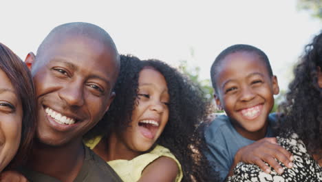 Außenporträt-Einer-Mehrgenerationenfamilie-Im-Heimischen-Garten-Vor-Gleißender-Sonne