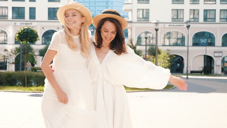 two women in white dresses and straw hats