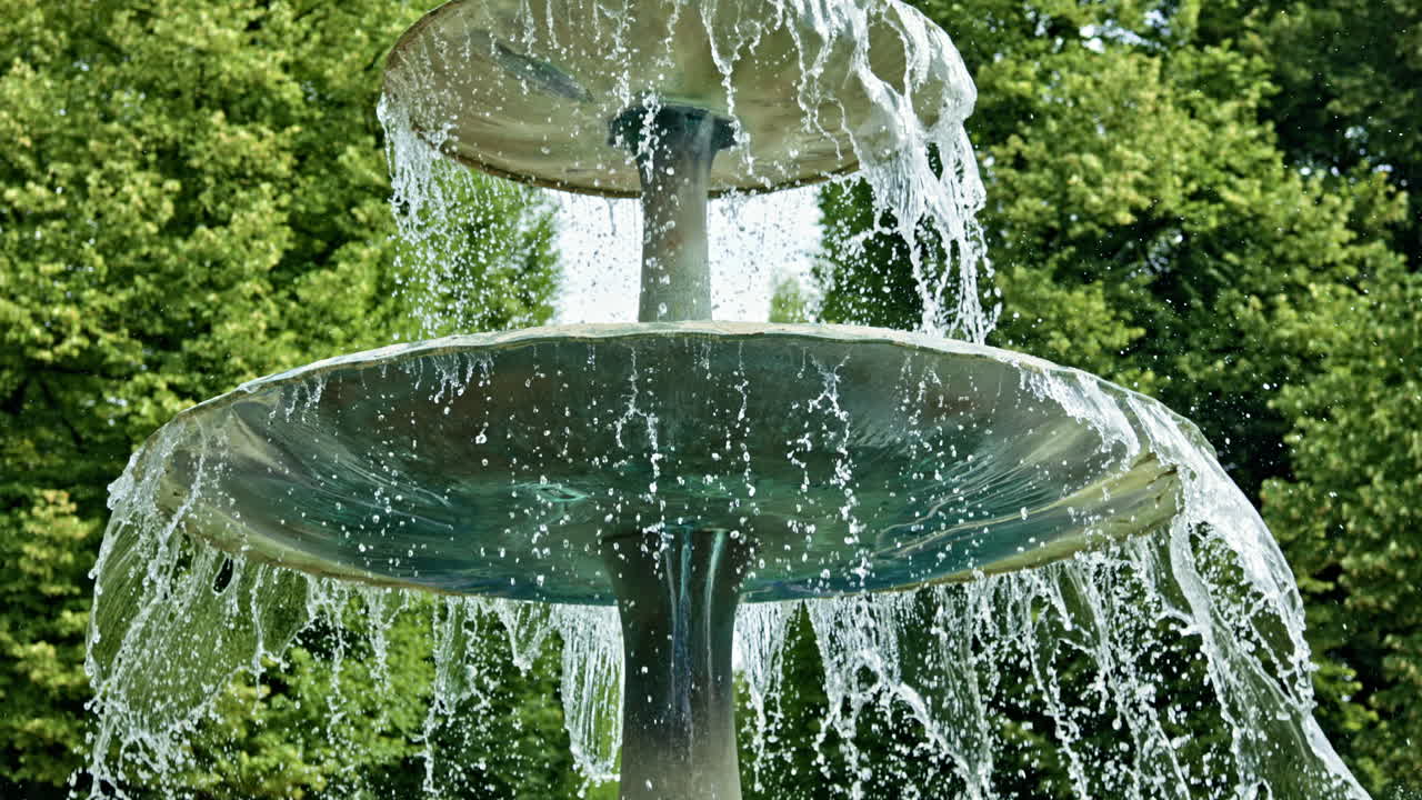 Une magnifique image en gros plan d'une fontaine en cascade magnifiquement entourée d'une végétation luxuriante, embrassant la beauté et l'élégance de la nature dans un cadre extérieur relaxant, parfait pour la méditation et la réflexion.