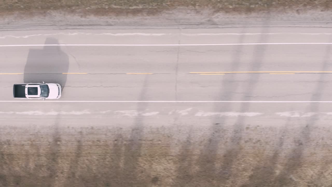 Drone looking down following a white truck on the road