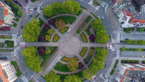 Vista-Aérea-Rotada-Desde-Arriba-De-Una-Enorme-Rotonda,-Llena-De-árboles-Y-Plantas-Verdes