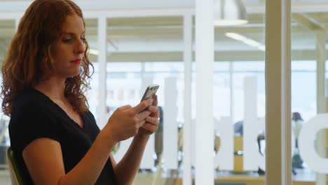 mujer de negocios usando teléfono móvil en la oficina 4k