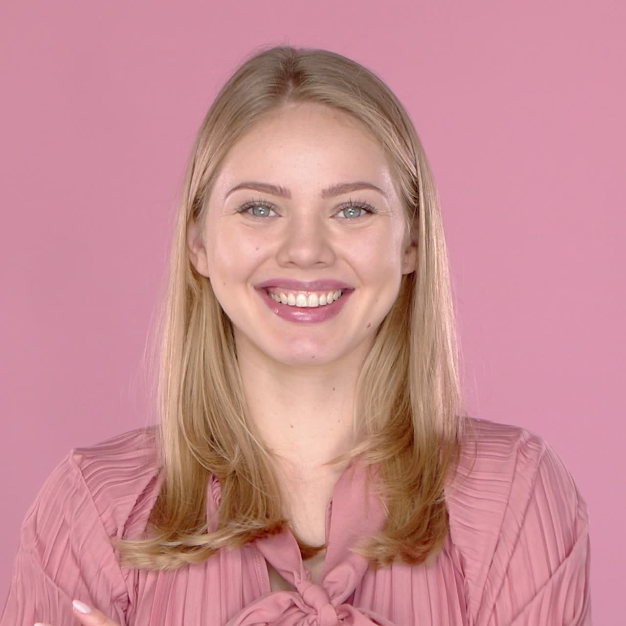 Portrait of young blonde positive female with cheerful expression  dressed in casual blouse