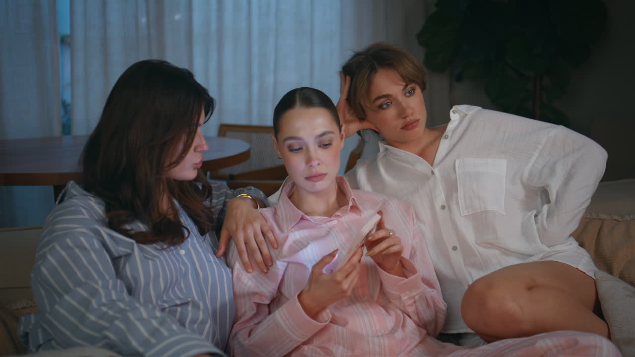 Calm friends relaxing home sofa at evening pajamas meeting closeup. Sad woman