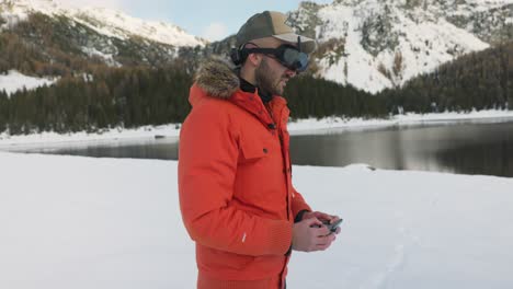 piloto de avión no tripulado con visor fpv controlando dji avata quadcopter con control remoto inalámbrico rodeado de hermosas montañas y paisajes nevados
