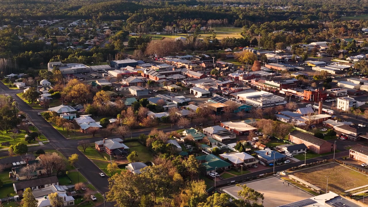Ripresa aerea con drone di strade suburbane e architettura a Coonabarabran, Australia al tramonto