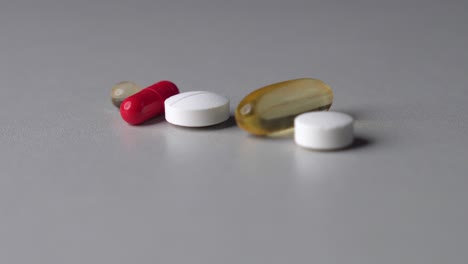 rack focus of different color and shape pills and capsules on table surface