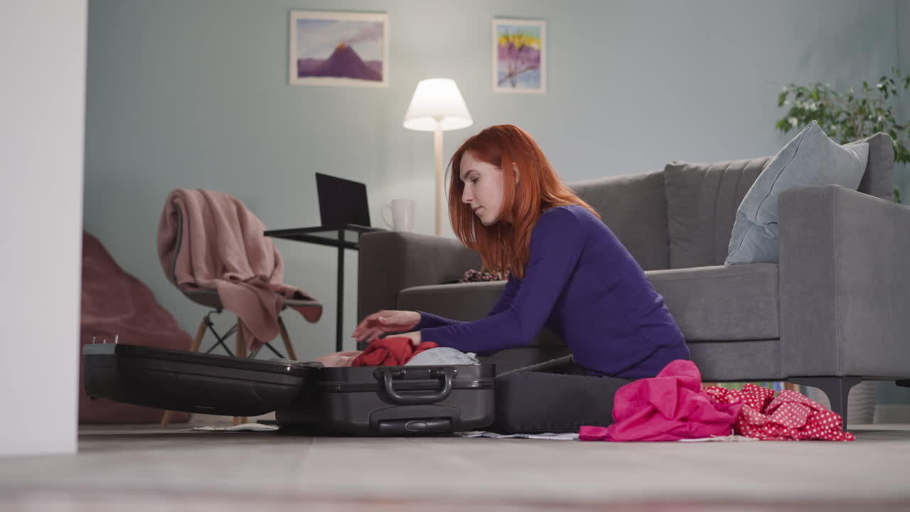 mujer enfocada con cabello rojo toma las cosas aparte en casa