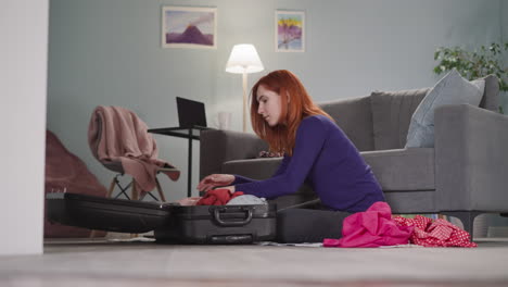 une femme concentrée avec des cheveux roux décompose les choses à la maison