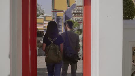 couple walking through red doorway