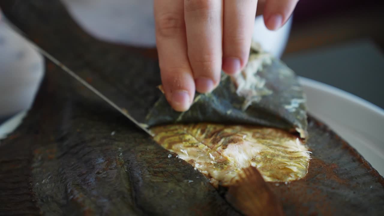 훈제 생선 껍질을 천천히 벗겨내는 사람의 손, 가까이서 보기