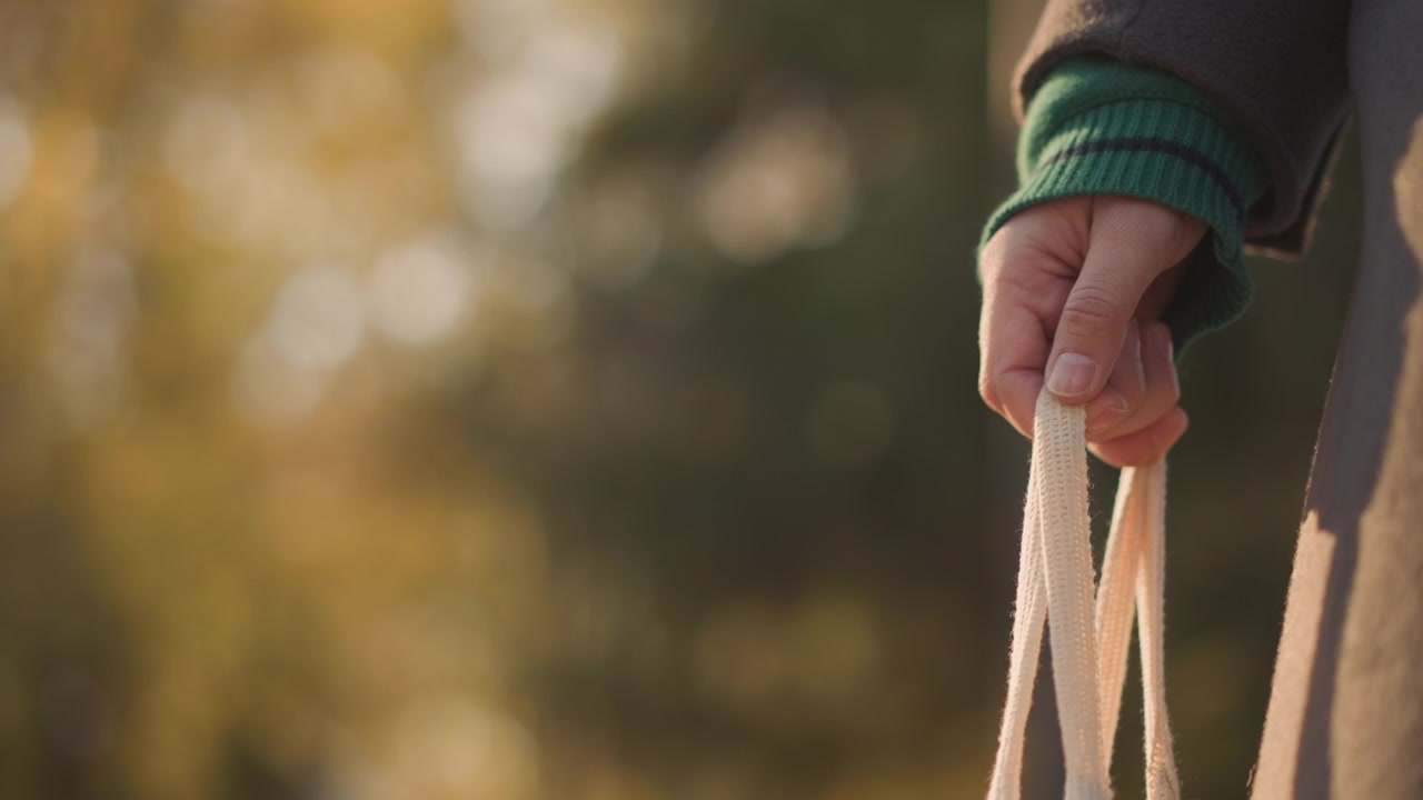 Persona che tiene una borsa della spesa riutilizzabile all'aperto in autunno