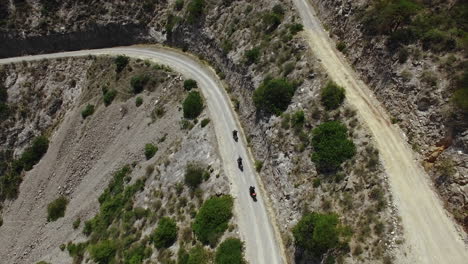 aerial of motorcycle riders riding motorbike on mountain roads