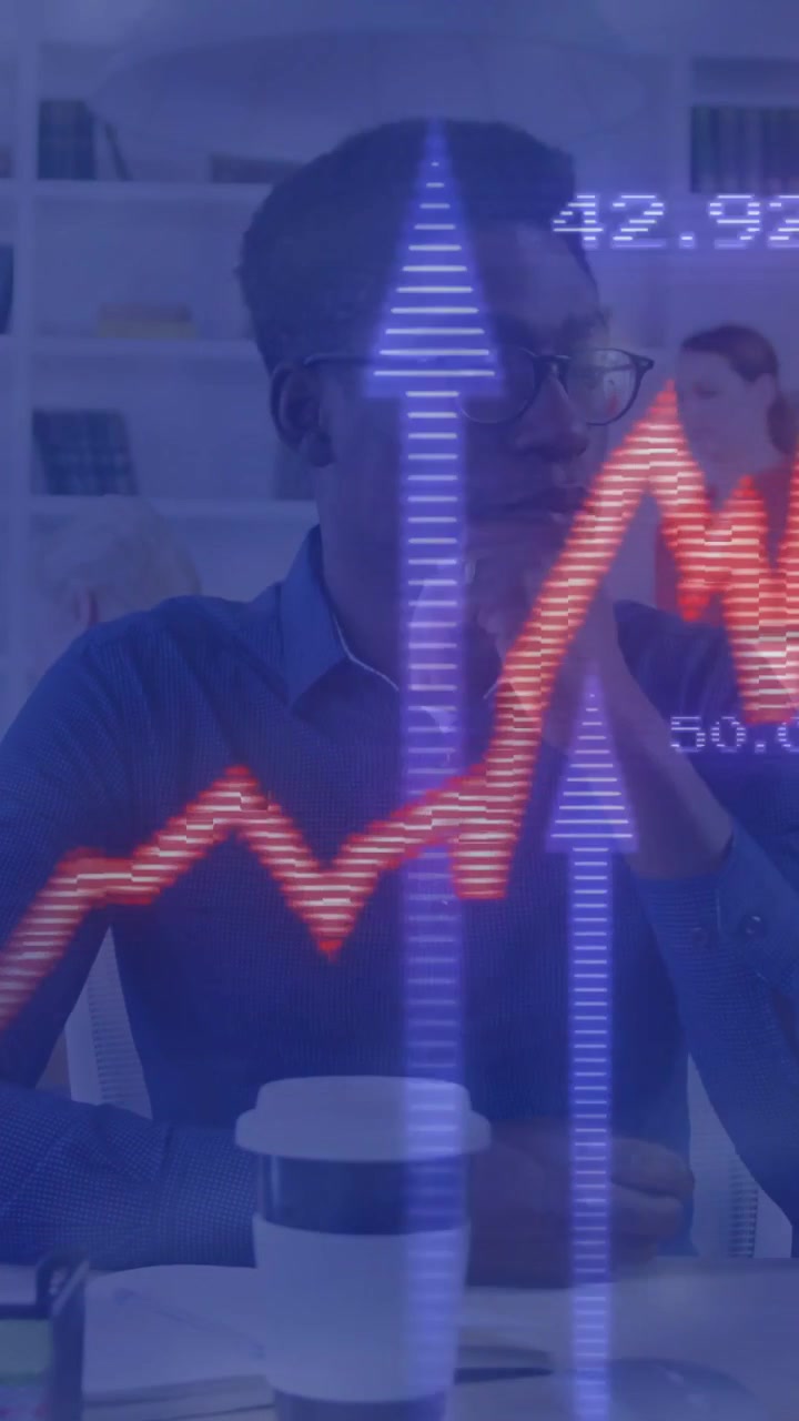 Vertical video: Male analyst reacting to pulsing finance graph, touching chin, evaluating near cup