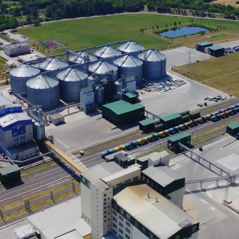 granary for agricultural products. flight over the aluminum containers for storing grains. silver elevators on field. aerial view.