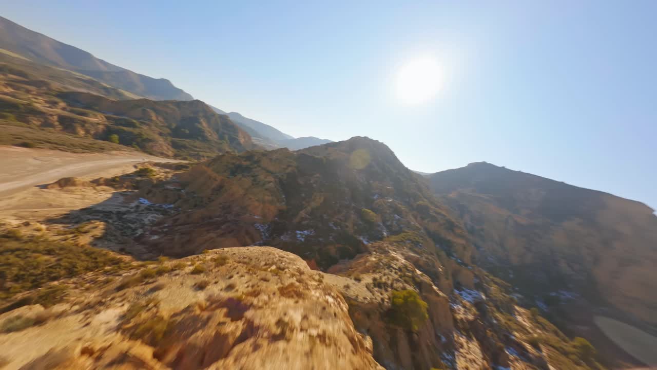 건조한 사막 풍경에서 산 능선을 따라 빠르게 날아가는 서사시 fpv 공중