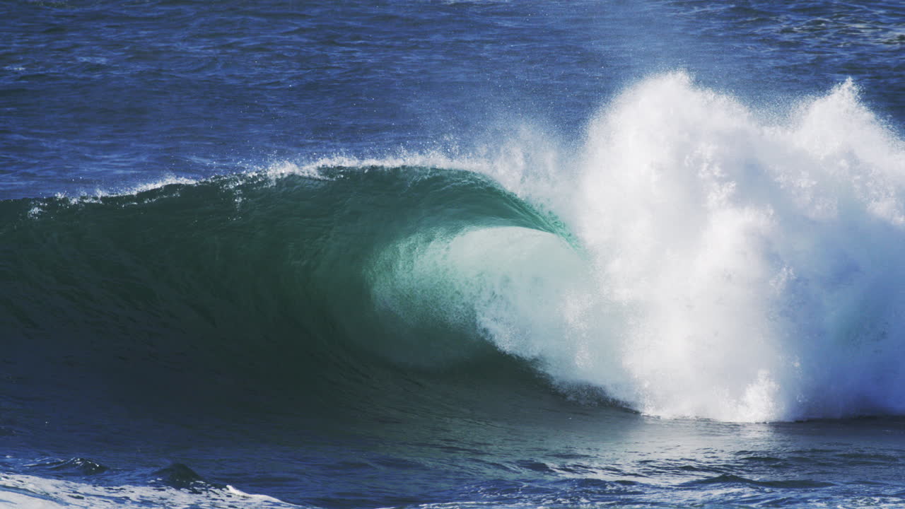 Slow motion barrel with layered mist and glowing textures rolling into shore