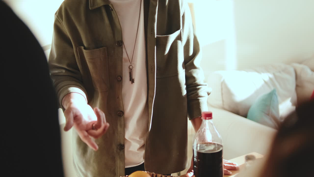 A gathering of people at a table with soda bottles