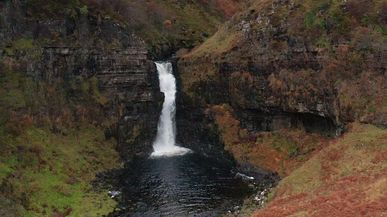 vuelo de drones aéreos en cámara lenta de la cascada de otoño lealt en skye escocia otoño