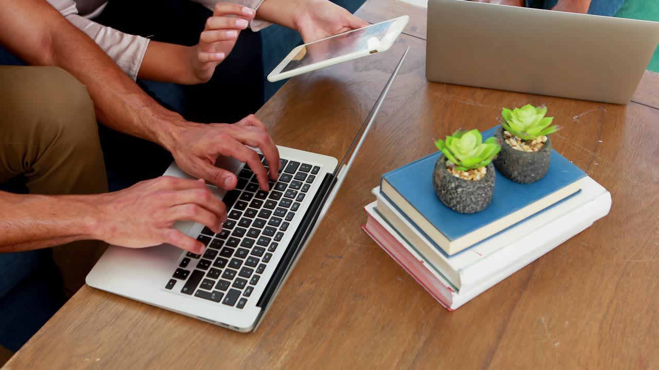 ejecutivos que usan tabletas digitales y computadoras portátiles en la oficina 4k