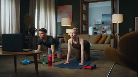 woman stretching body man at home. young couple standing on knees bending backs.