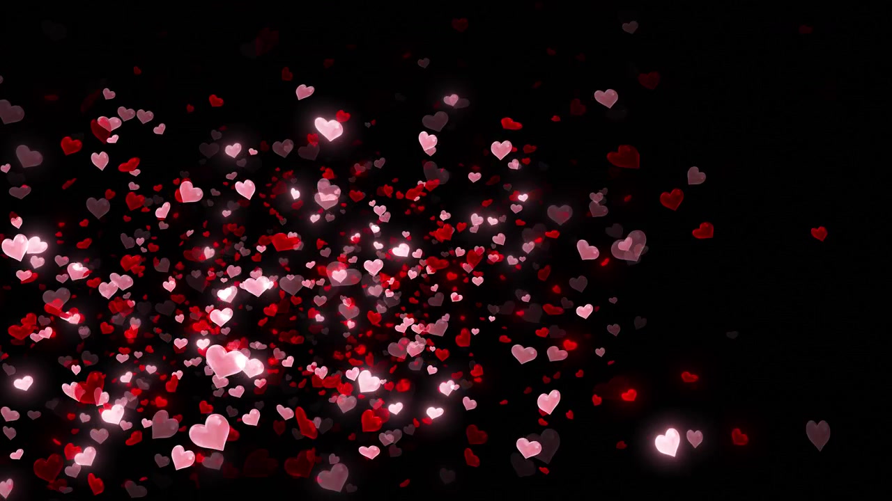 Cuori rossi e rosa si disperdono nello spazio nero in un'esplosione romantica luminosa creando un'atmosfera festosa
