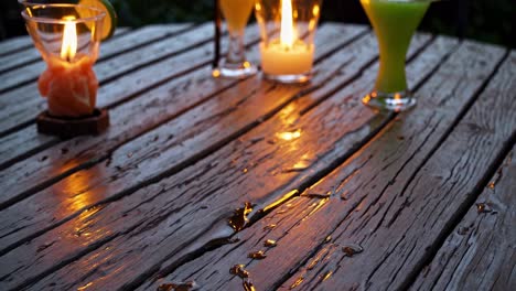 warm light is reflecting on a wet wooden surface with planks and drops of water, creating a cozy and inviting atmosphere during a tropical evening
