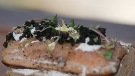 salmón a la parrilla cubierto con caviar negro, hierbas y mayonesa