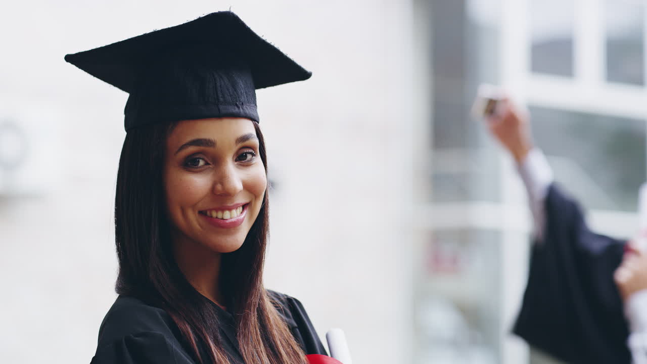 un joven graduado posando mientras sus compañeros graduados