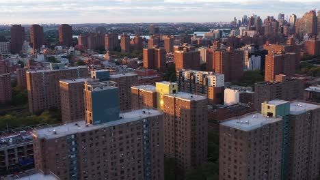 aerial footage quickly slides across housing projects and skyline in harlem nyc at sunrise golden hour