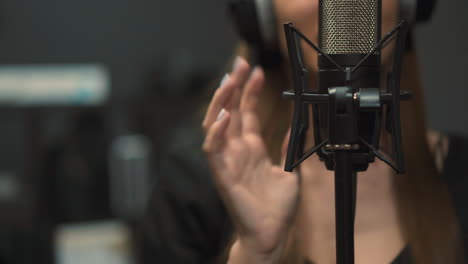 woman singer records new song in studio focus on microphone