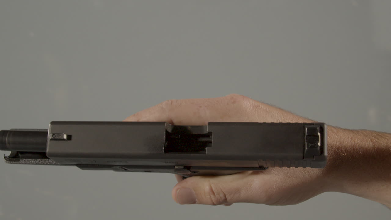 Hand showing mechanics of empty handgun and dry firing pistol