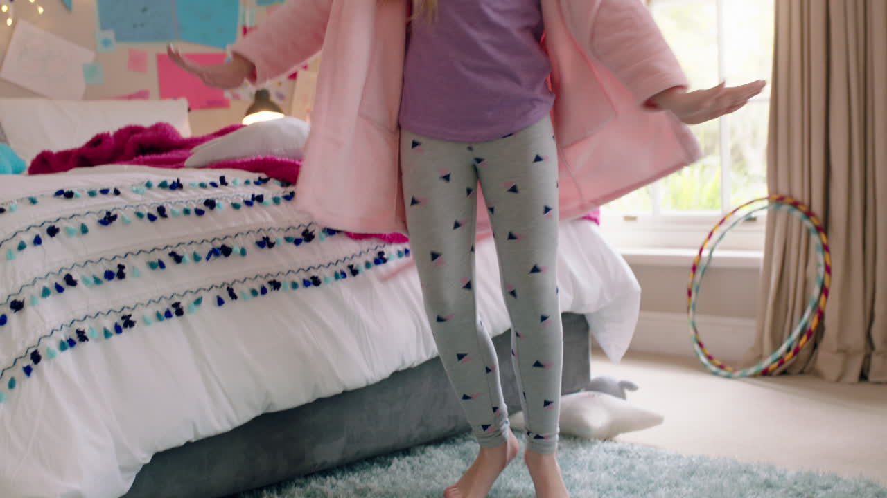 happy little girl dancing in bedroom having fun playful morning wearing pajamas enjoying weekend at home