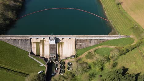 4K-flying-over-hawkridge-reservoir,-drone-moving-forward-over-the-water-dam-wall-and-over-the-reservoir,-60fps