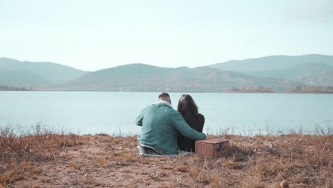 young couple sitting and hugging by the riverisde