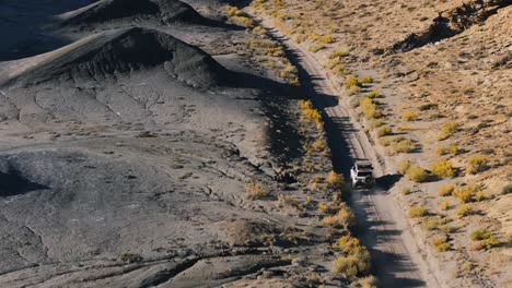 Driving-along-moonscape-road-of-Factory-Butte-in-Utah,-USA