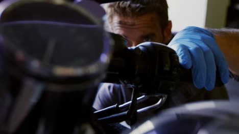 male mechanic repairing motorbike in repair garage 4k