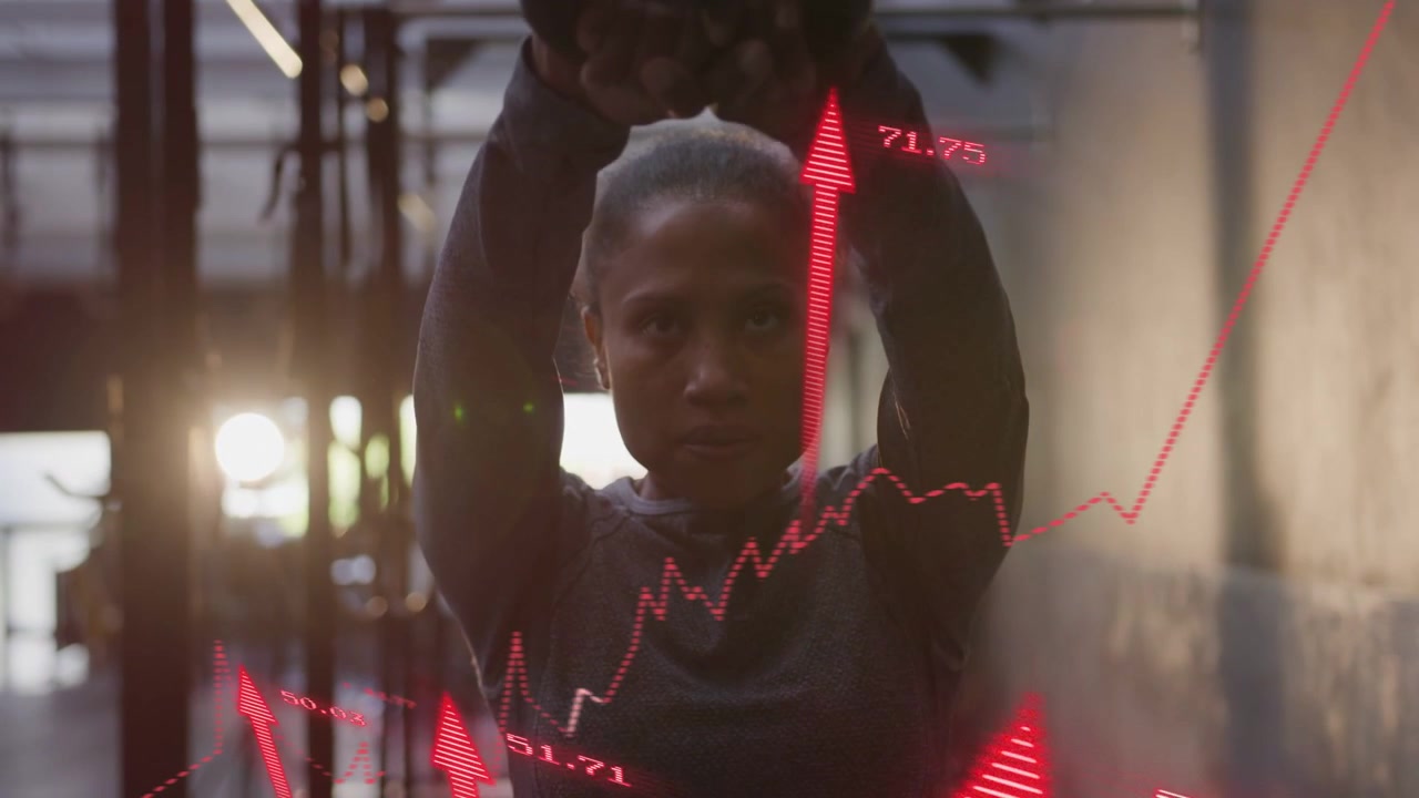 Woman gripping medball lifting slamming overhead in fitness while red charts overlay showing gains