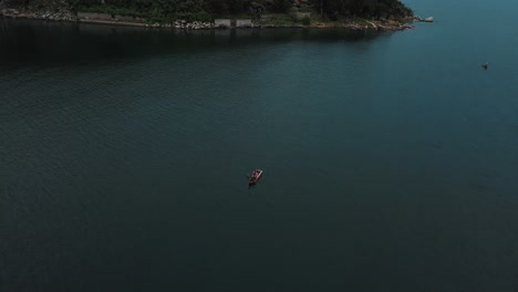 drone aerial view of a man on a boat in lake atitlan, guatemala