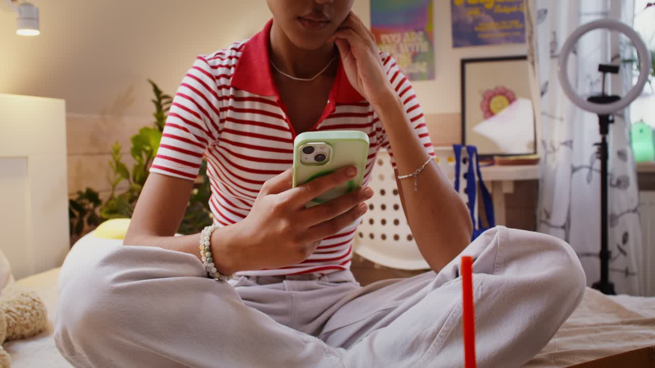 adolescente usando un teléfono inteligente en su dormitorio
