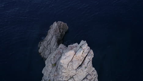 Fly-over-drone-shot-of-Ibiza's-iconic-rock-Benirrás-at-sunrise