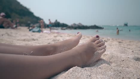 Die-Menschen-Ruhen-Sich-Am-Meeresstrand-Aus-Und-Nehmen-Frauenfüße-In-Der-Sonne