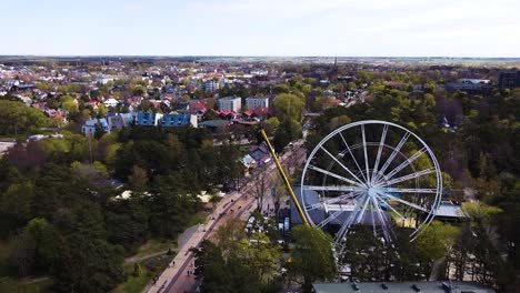 white ferris wheel under construction with cityscape of palanga, aerial view