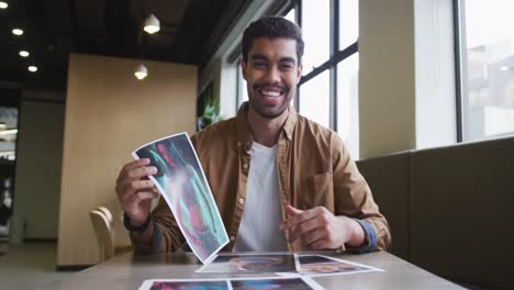 Mixed-race-businessman-having-a-video-chat-going-through-paperwork-modern-office