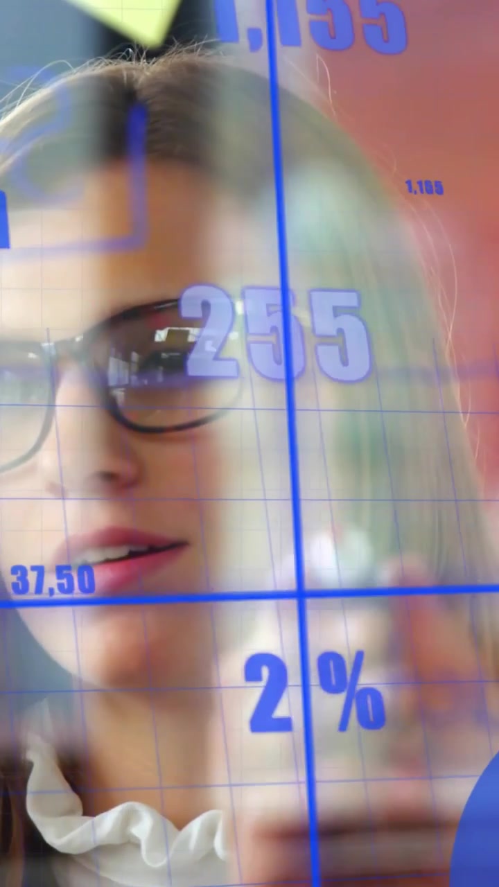 Video verticale: Donna che tocca un display trasparente, aggiornando i dati finanziari e spiegando il grafico mensile