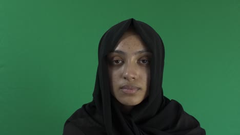 young ethnic muslim female wearing hijab looking at camera