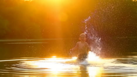 child splashing in golden water at sunset