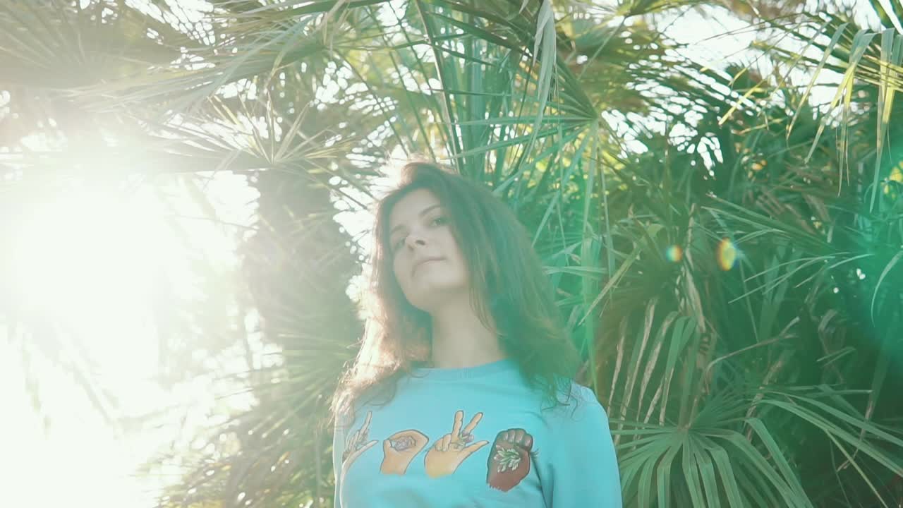 mujer en una tee gráfica entre las palmeras