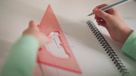 elementary school student draws square shape side at desk